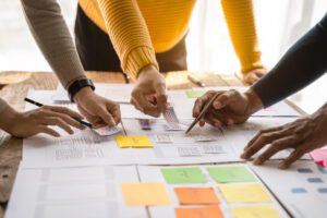 Hands holding sticky notes while creating a marketing plan.
